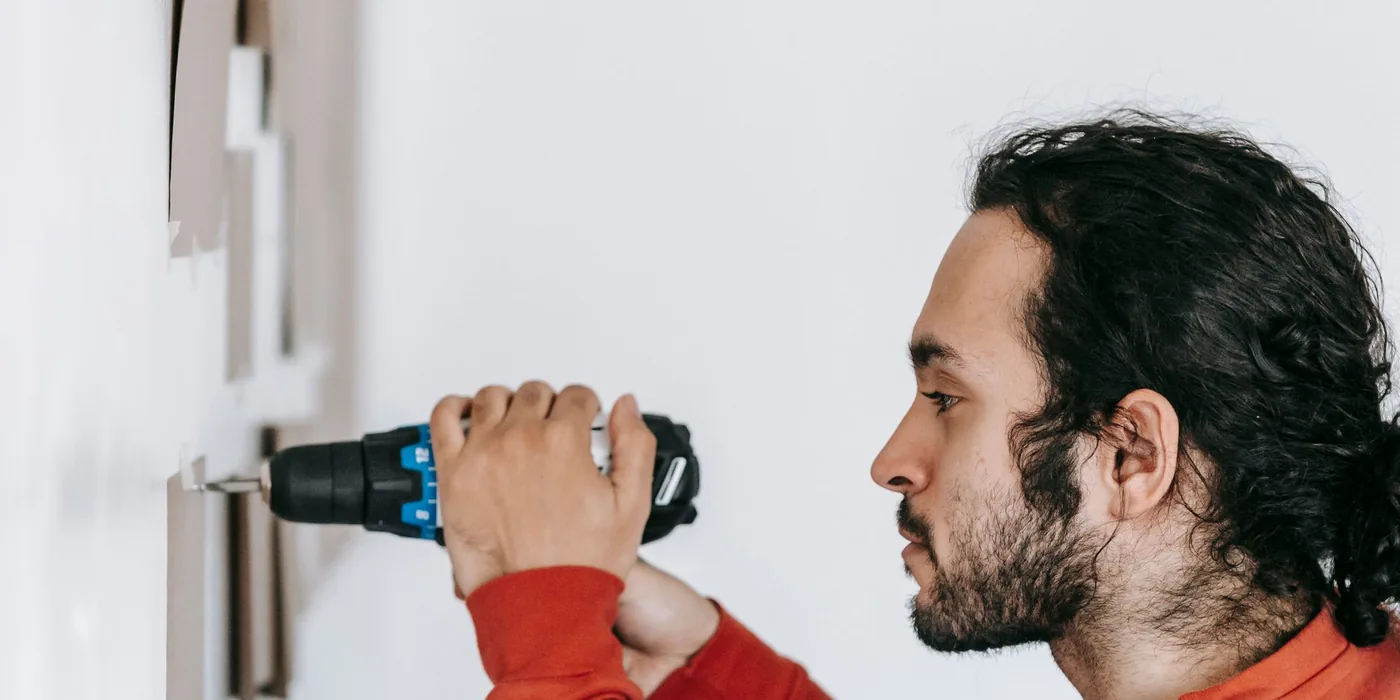 Profesional de HELPY taladrando una pared para montar un elemento en un local de Las Palmas